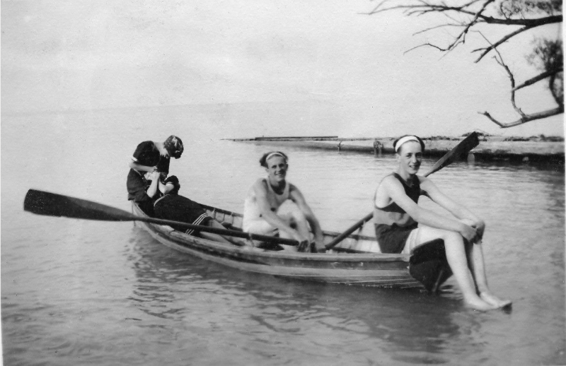 Historical image of group of three people in a canoe.